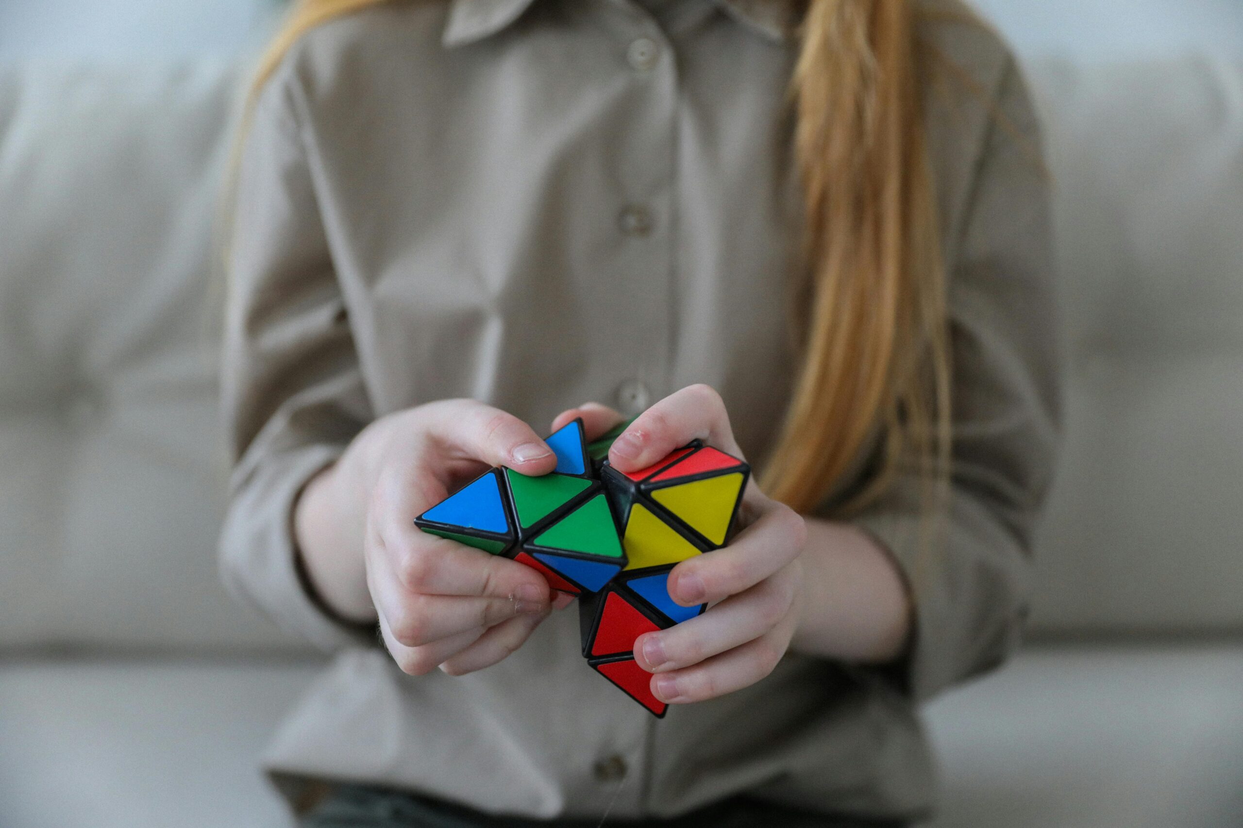 imagen de un niño o una niña autista con un cubo de rubik de colores en las manos